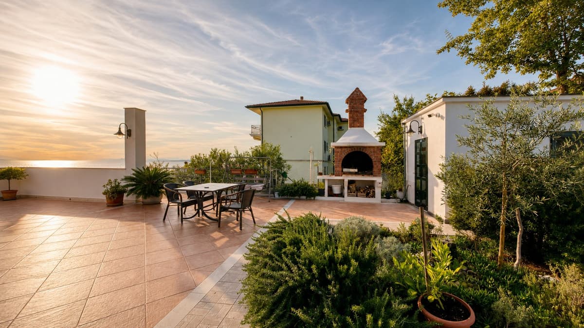 The garden terrace at sunset — the brick barbecue, olive trees and herbs