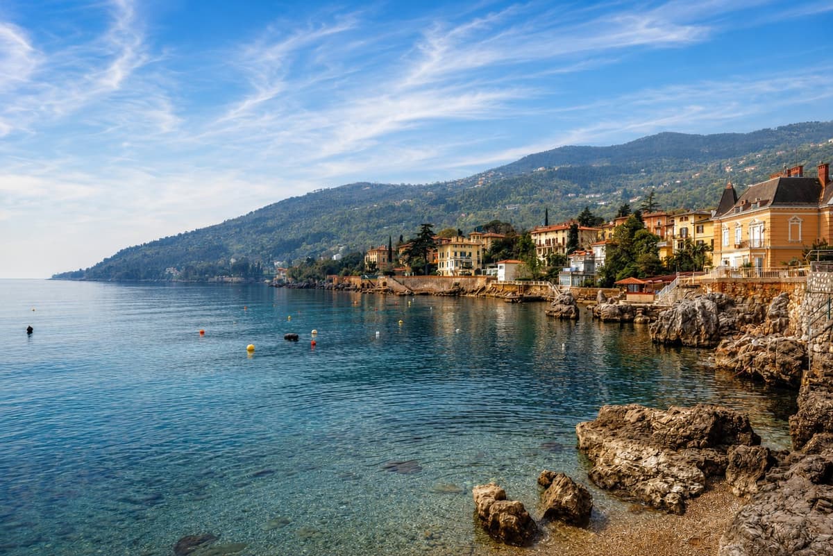 Lovran's rocky coast and waterfront villas in clear morning light